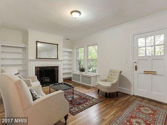 Living room with wood-burning fireplace, built-in shelving, coat closet (not shown). Currently has TV mounted above fireplace.