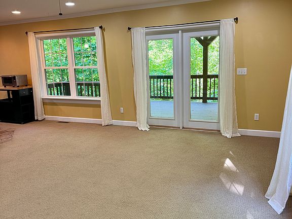 Double patio doors going to back deck surrounded by forest.