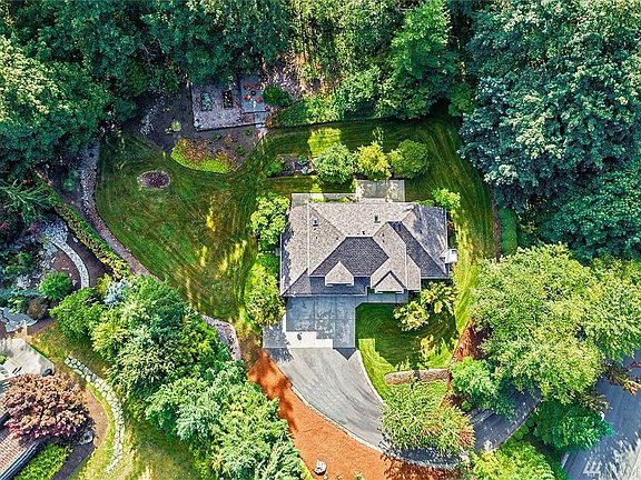 Aerial shot of the property. Private 36,000 Sq Ft lot, large driveway, back patio, vegetable garden beds, park-like backyard.