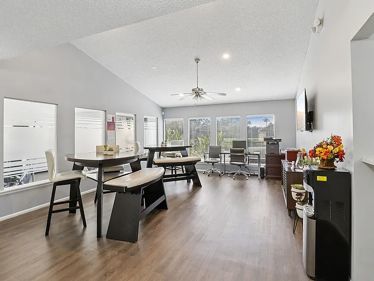Bright and modern community room with sleek furniture, large windows, and stylish wood flooring, perfect for gatherings.