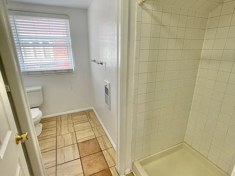 Bathroom entrance with shower stall on the right