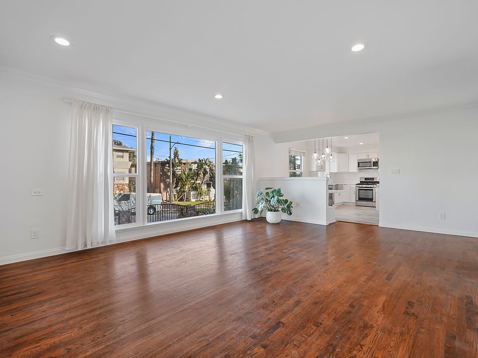 Large living room with lots of natural light, looking toward entrance.