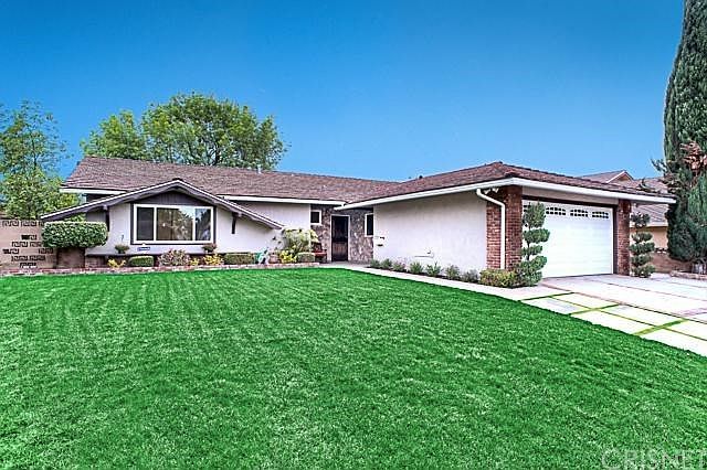 The south facing front yard with handsome curb appeal, two car attached garage with direct access into the house, and cement driveway.
