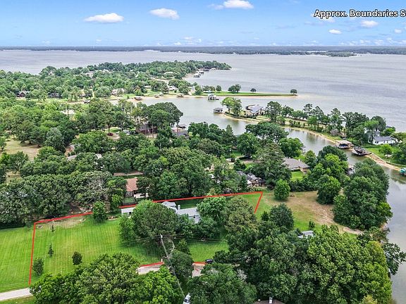 Aerial view showcasing the expansive four-lot property with beautifully maintained grounds, mature shade trees and spacious green lawns.