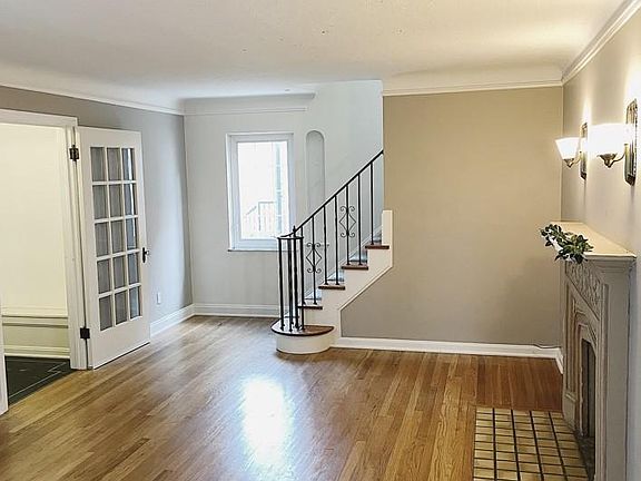 Light and bright living room - Attention to detail with hardwood floors, wrought iron staircase, decorative fireplace and lighting