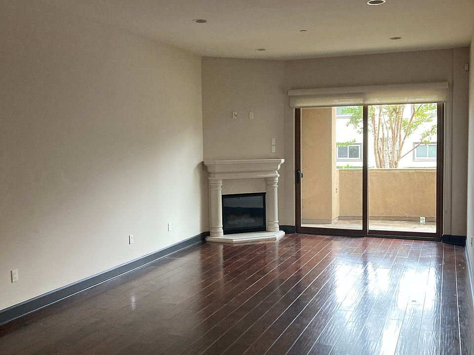 Gas fireplace, wood floors, roller shades, dimmable lights, green view.