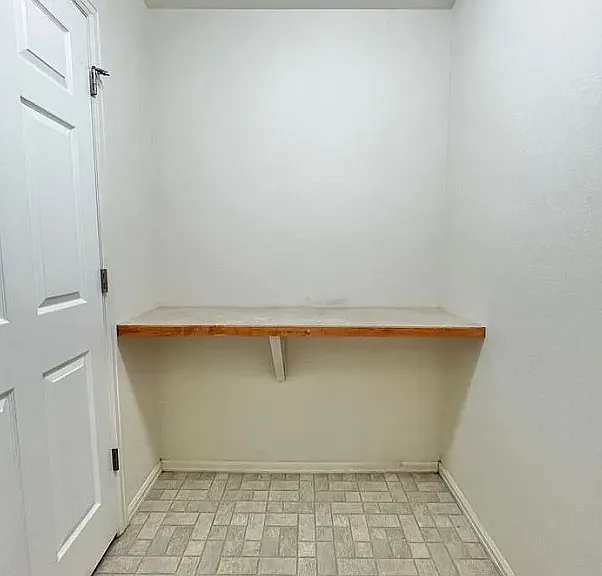 In the laundry room, a counter is built in opposite the washer and dryer.