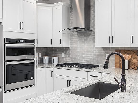 Gourmet Kitchen with White Cabinetry and Ceramic Tile Backsplash