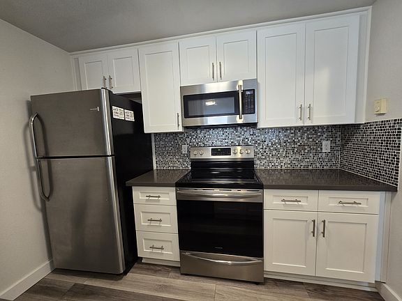 Kitchen with all stainless steel appliances. Completely remodeled, granite countertops and tile backsplash.