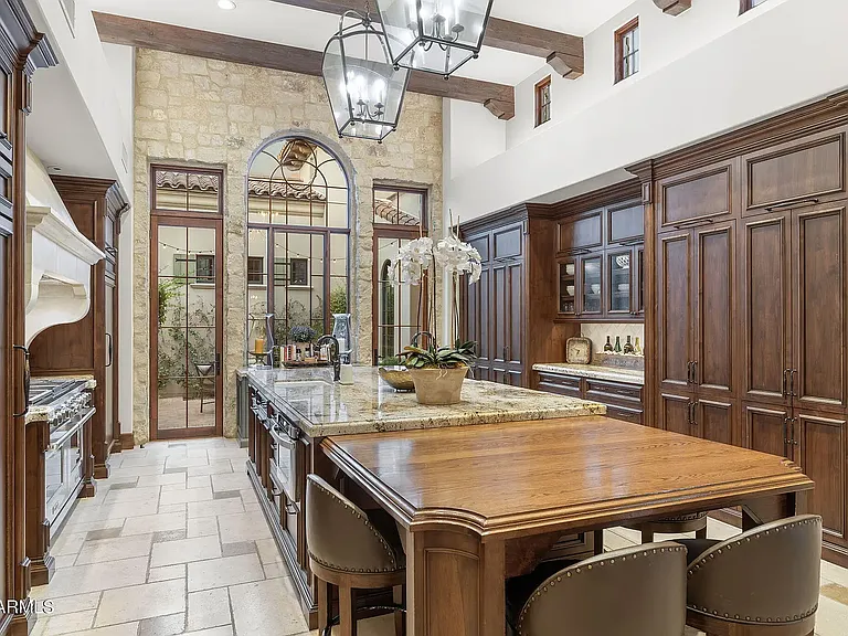 Custom cabinetry and stone arches define this stunning gourmet kitchen.