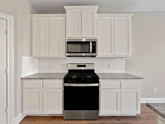 The kitchen has beautiful white cabinets.