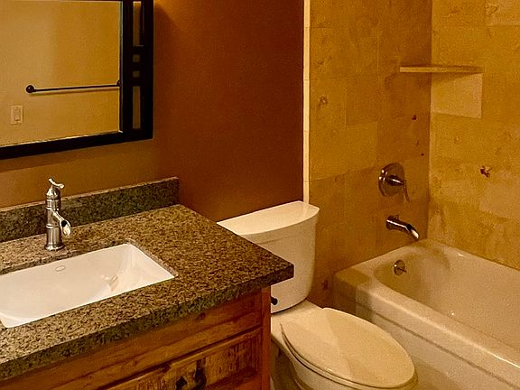 Guest bath / Travertine stone tiles, granite vanity top.