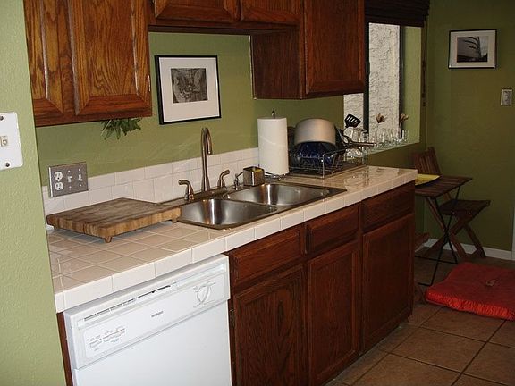 Kitchen has tile backsplash and countertops
