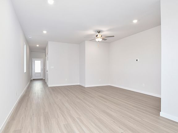 The family room is spacious and has a ceiling fan.