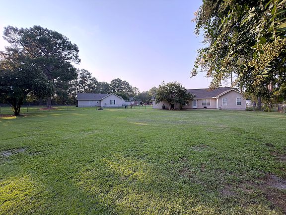 Expansive fenced backyard shaded by mature trees_lawn care included