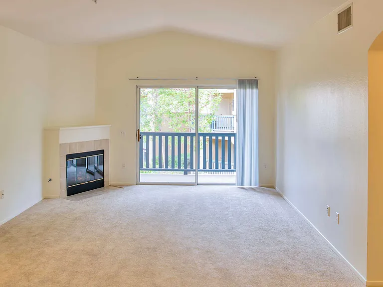 Carpeted Living Room with Balcony and Fireplace