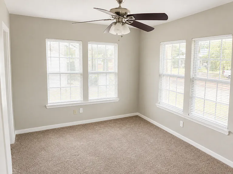 Spacious Primary Suite with Abundant Natural Light
Unwind in this bright and generously sized primary bedroom featuring multiple large windows, a ceiling fan, and a private en-suite bathroom for added comfort and privacy.