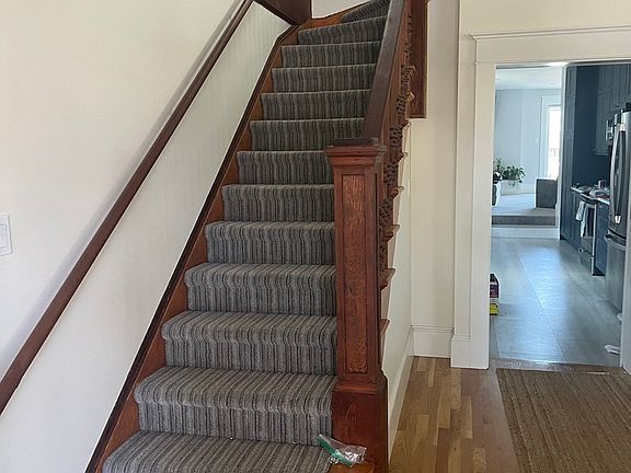 Original wood stair case. Carpeted to dampen noise.