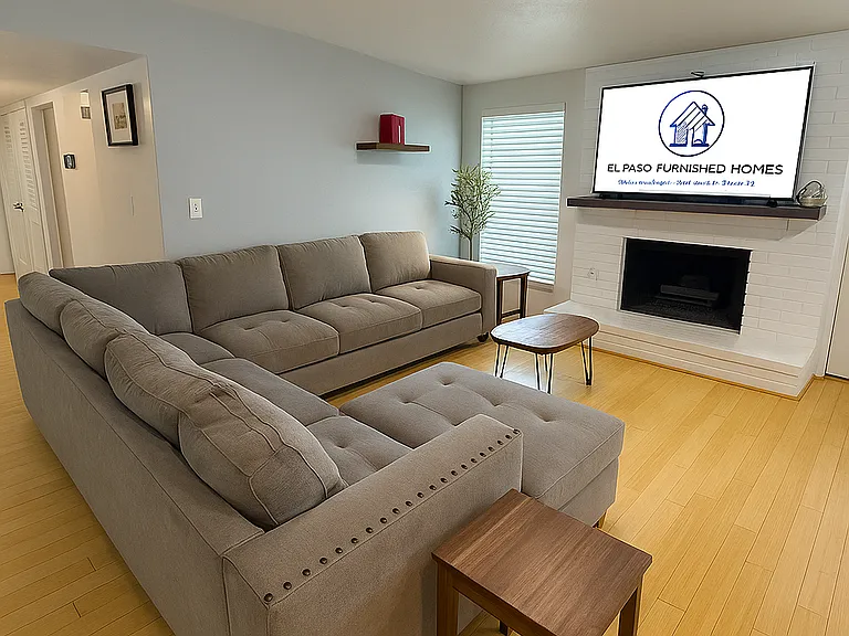 Bright and cozy living room with oversized sofa and 58" 4K Smart TV.