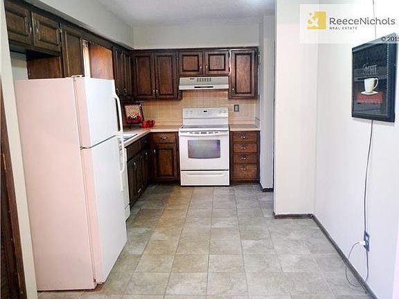 Kitchen with tiled floors has lots of cabinets, includes all appliances.