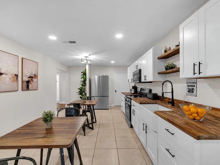Eat-in kitchen with ample cabinetry, wood countertops, stainless appliances, and a dining area for everyday meals.
