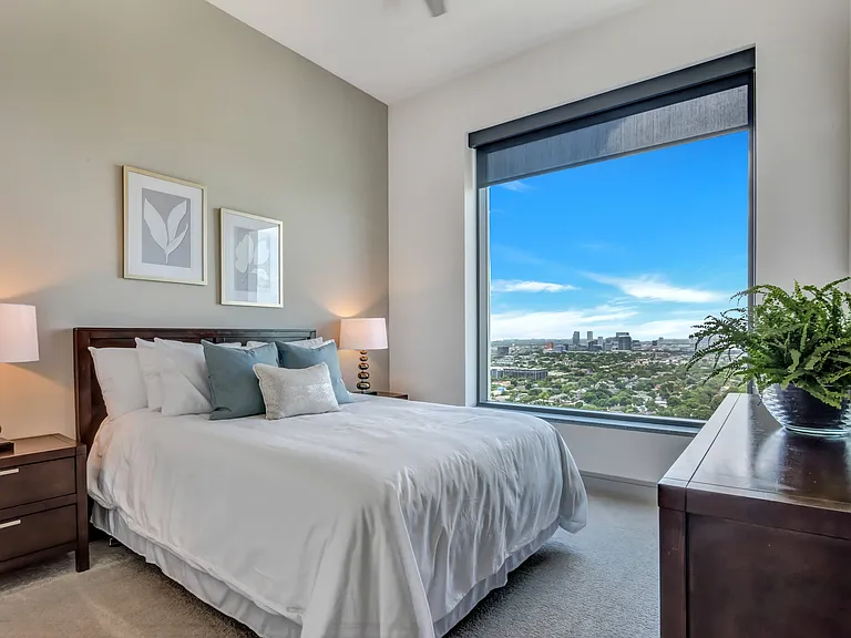 Bedrooms feature high-ceilings and oversized picture windows, providing sweeping views of Houston