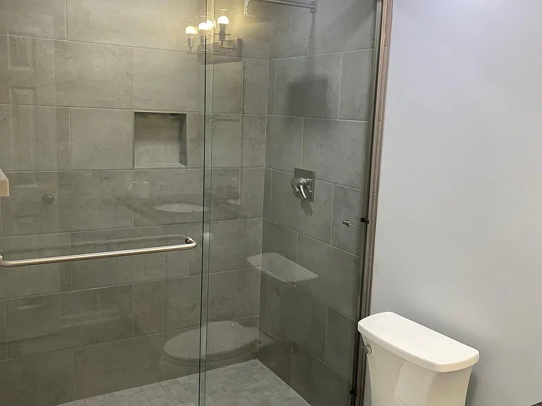 Newly renovated bathroom with large walk-in shower, ceramic tile flooring, and recessed lighting.