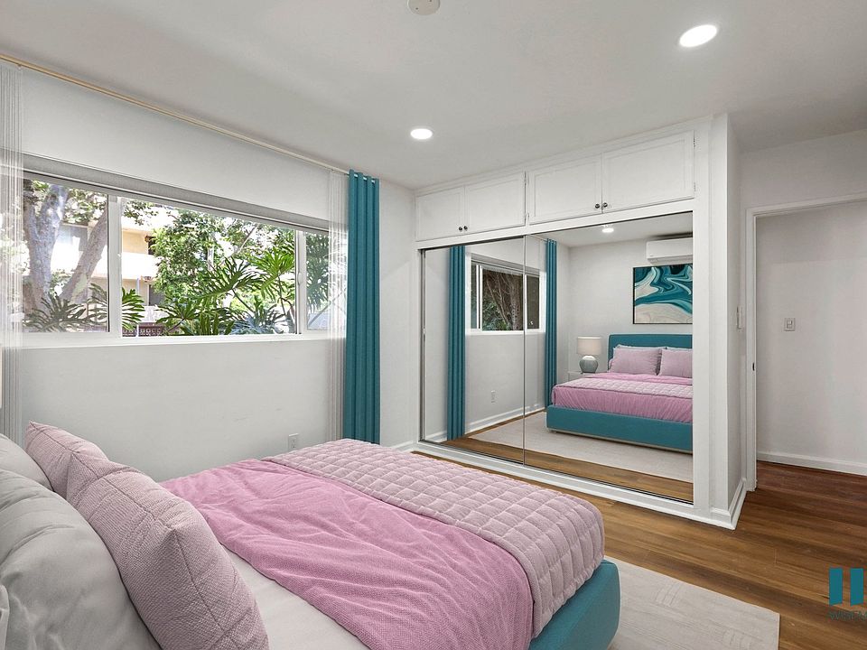 Bedroom with Vinyl Flooring and Mirrored Closet with Overhead Storage