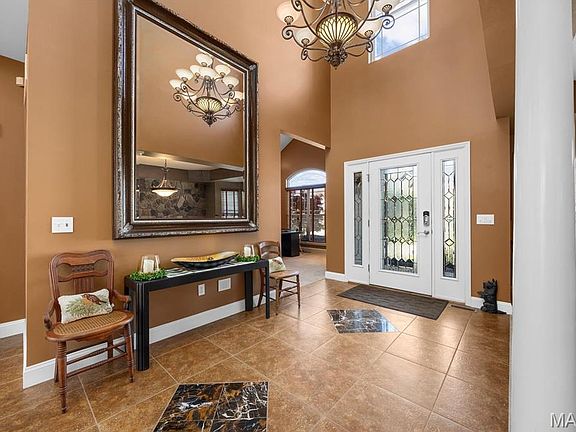 Dramatic foyer featuring soaring ceilings, elegant lighting, and an inviting entrance