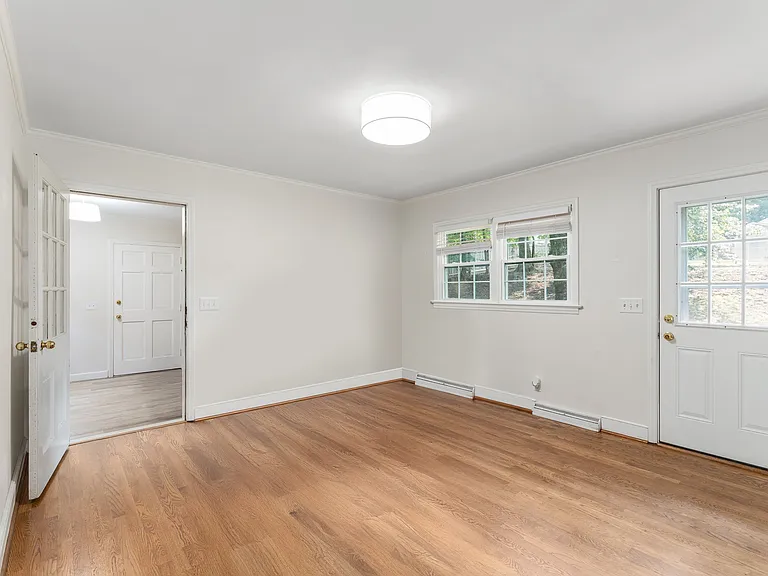 Large light filled dining room with door to backyard.