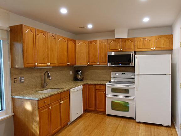 Kitchen with granite countertop. Brand new over the range microwave with strong fans which can ventilate cooking smells to the outside. The kitchen has recessed lights on a dimmer switch.