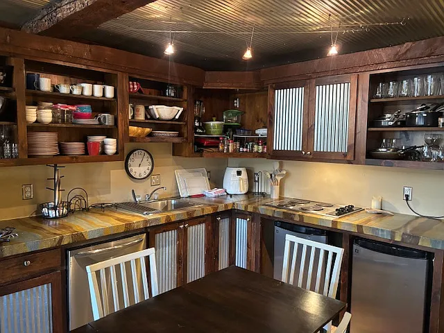 Kitchen with stovetop, convection microwave, two mini fridges, air-fryer, dishwasher, and dining table