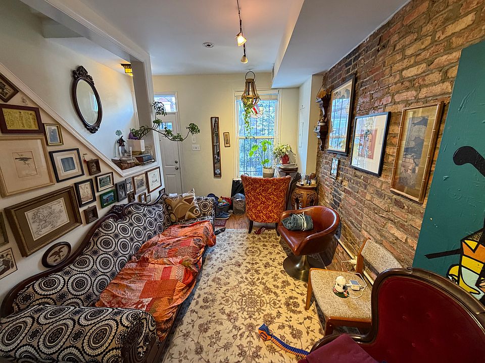 cozy living room with south-facing window and exposed brick wall.