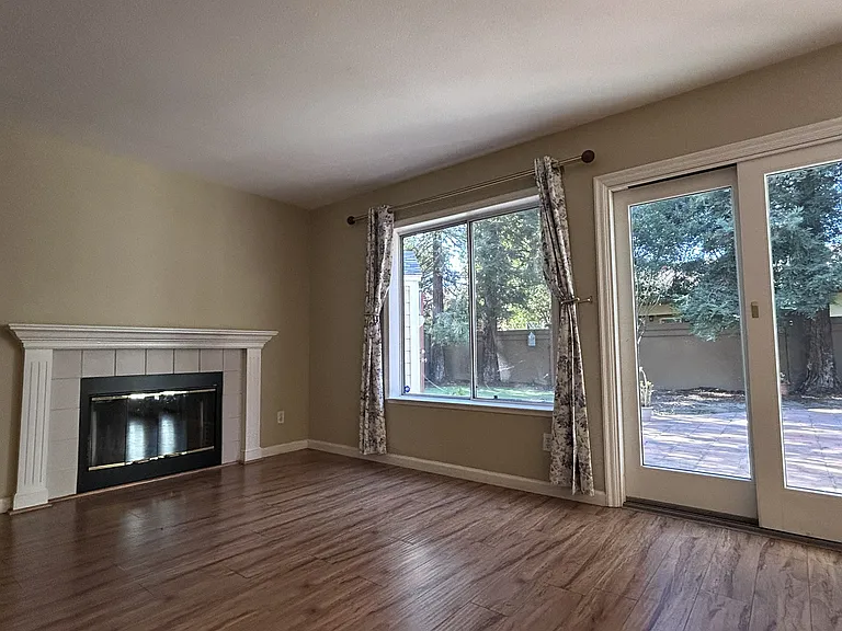 Fireplace and patio door & window towards backyard