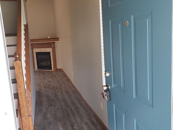 Front door entryway. View of fireplace and stairs to 2nd level.