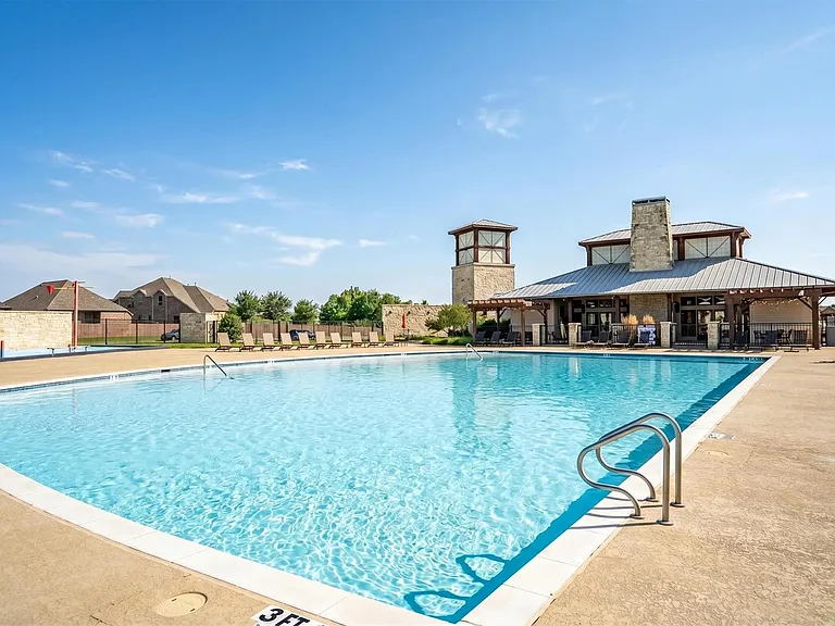 Expansive community pool with a surrounding concrete deck