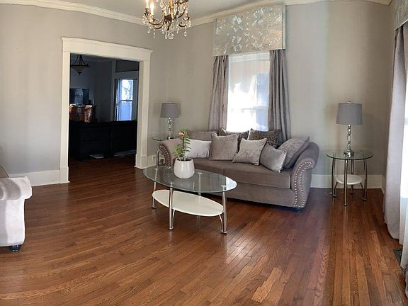 Formal living room (12'x13') Wood floors, original wood work, crown molding, high ceilings and antique chandelier.