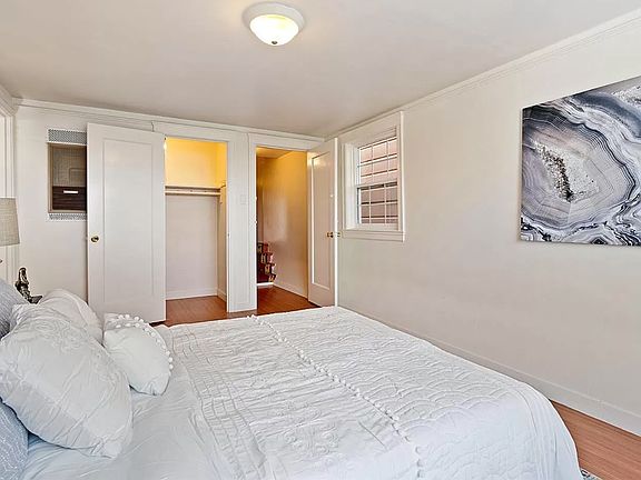 Main bedroom with walk-in closet, and wall heater.