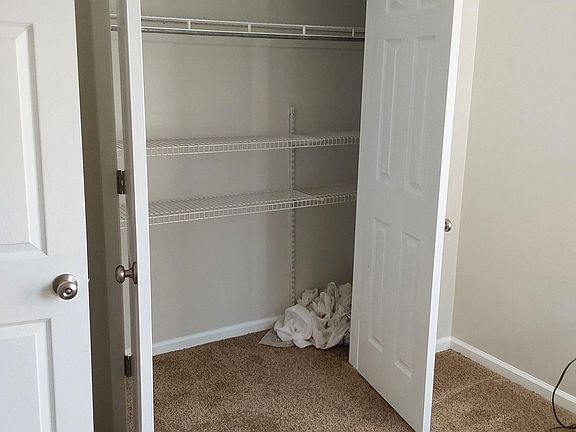 Bedroom storage area with a wide reach-in closet featuring wire shelving and hanging space for organized wardrobe storage.