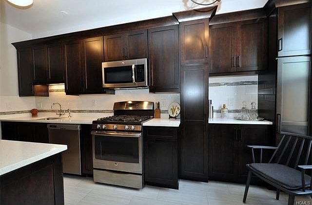 Stunning New Eat-in-Kitchen with Quartz counters, Custom soft close cabinets and Stainless Steel appliances including a dishwasher, range, microwave and French door refrigerator.   There is a decorative tile back splash and new tile floor.