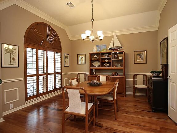 Rich Brazilian Tigerwood Flooring, Plantation Shutters, Updated Chandelier & Double Crown Molding.