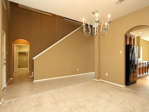 ANOTHER VIEW OF THE DINING ROOM AND THE FOYER. THE ARCHED DOORWAY GOES TO THE KITCHEN.
