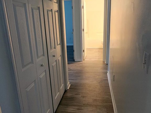 Hallway towards bedroom, laundry closet on left