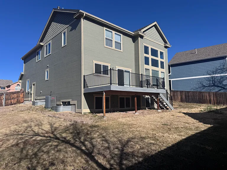 South view of the home, new deck and fence addition are not shown.