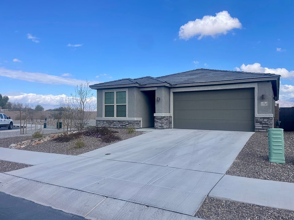 Front of house. 3 car tandem garage with overhead storage racks.