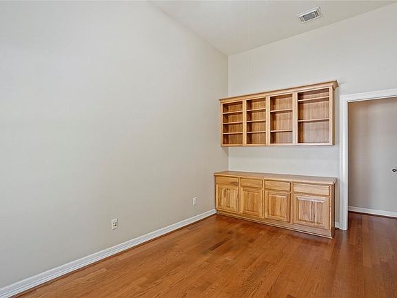 Custom cabinetry and large walk-in storage room in private study.