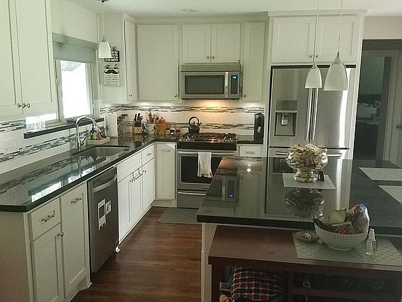 The open kitchen with over sized island. There is under cabinet lighting. The house will come with all appliances, including the cabinet-depth french door refrigerator.