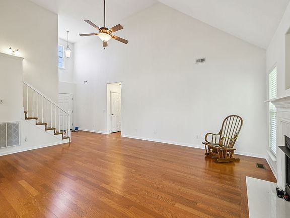 Vaulted ceiling, wood flooring in living room, cozy fireplace.