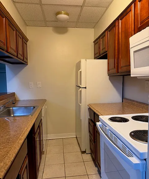 Kitchen equipped with stove, microwave, dishwasher, refrigerator and garbage disposal.