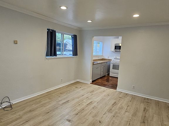 View of living room, kitchen and bedroom door